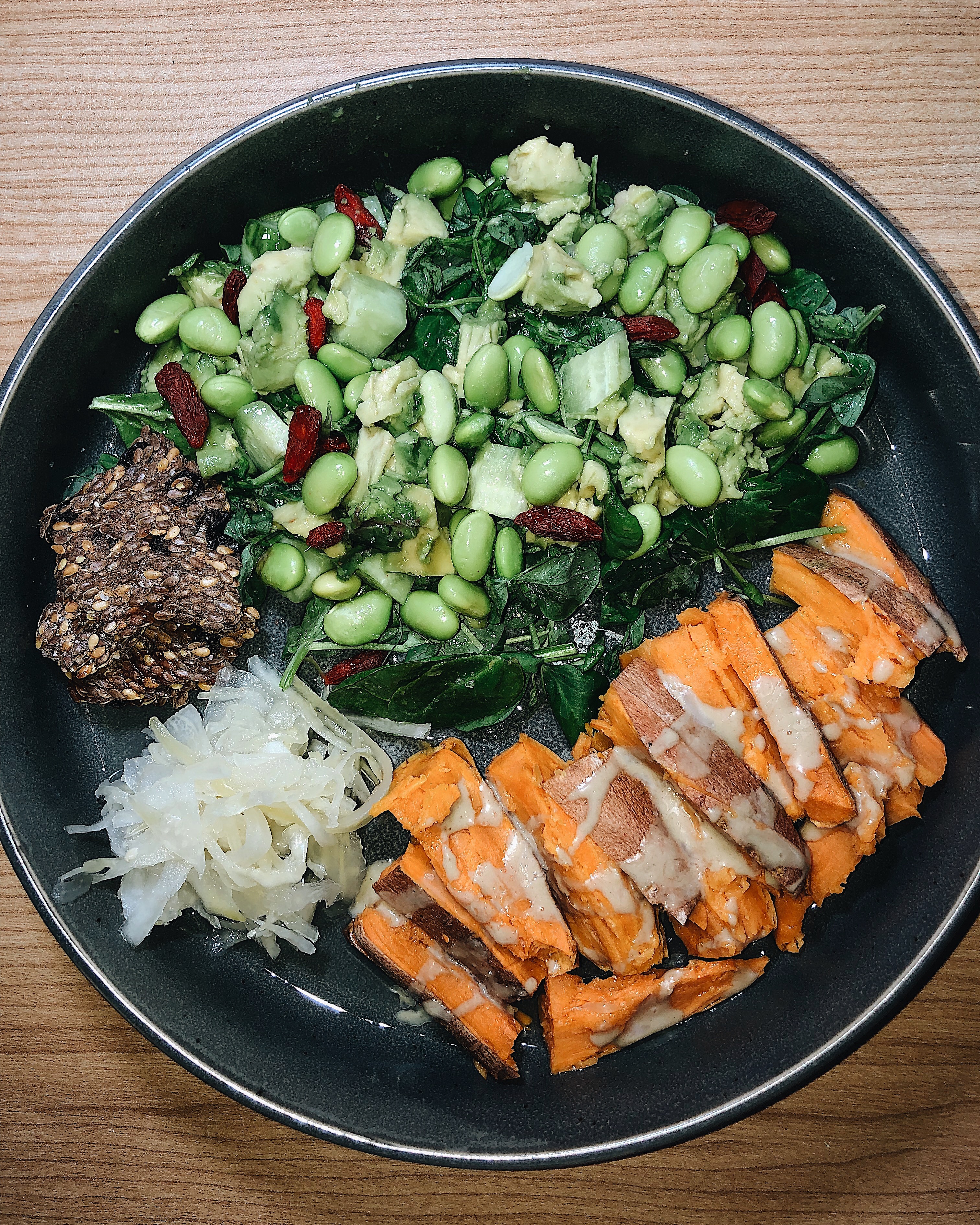 Bowl with greens, sweet potatoes, and tahini