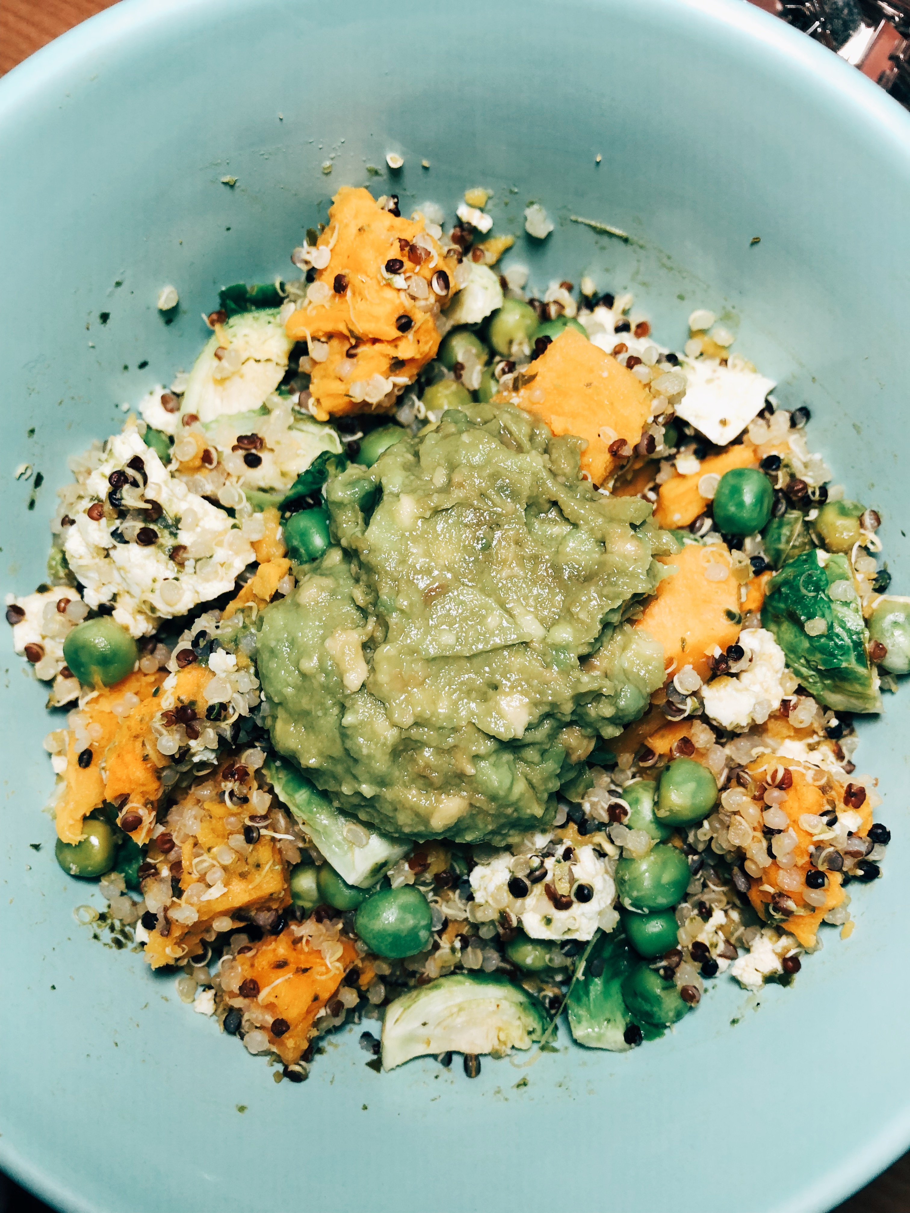 Vegan pesto bowl with quinoa, guacamole, and sweet potato